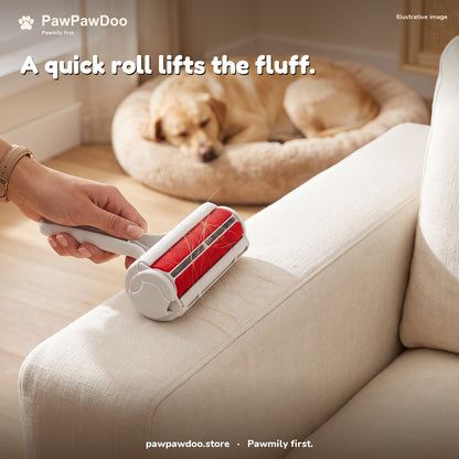 A hand rolls a few dog hairs off a sofa arm with the reusable pet hair roller while a dog sleeps in a Cozy Nest bed