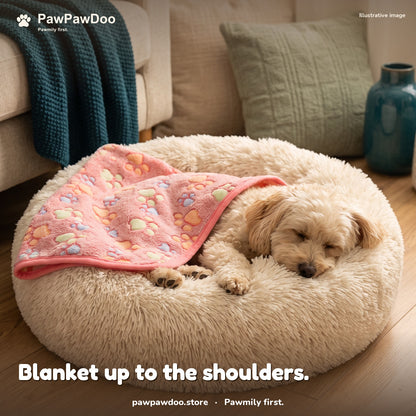 Small dog asleep in a Cozy Nest bed with a pink paw-print blanket tucked up to the shoulders